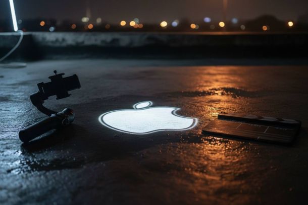 A glowing Apple logo projected onto wet pavement beside a gimbal and clapperboard at night.